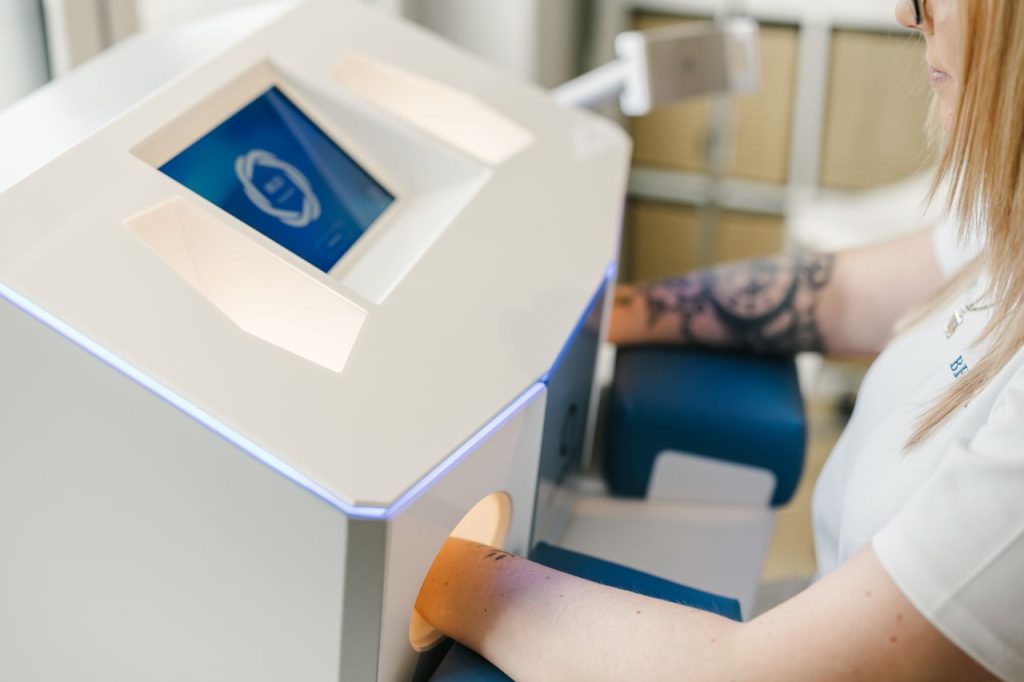 Wärme und Kälte Behandlung bei BODYforming in Winterthur. Frau hält ihre Hände in das Avacura Gerät um so Kälte- und Wärmereize zu bekommen.