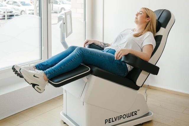 Klientin sitzt im Pelvipower Stuhl des Longevity Center BODYforming